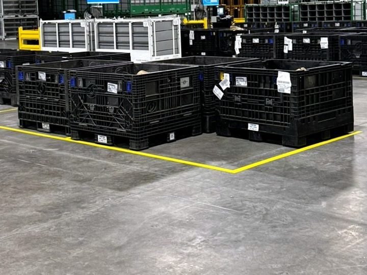 Parts storage bins on a clean warehouse floor with yellow lane lines in Hammond, Indiana