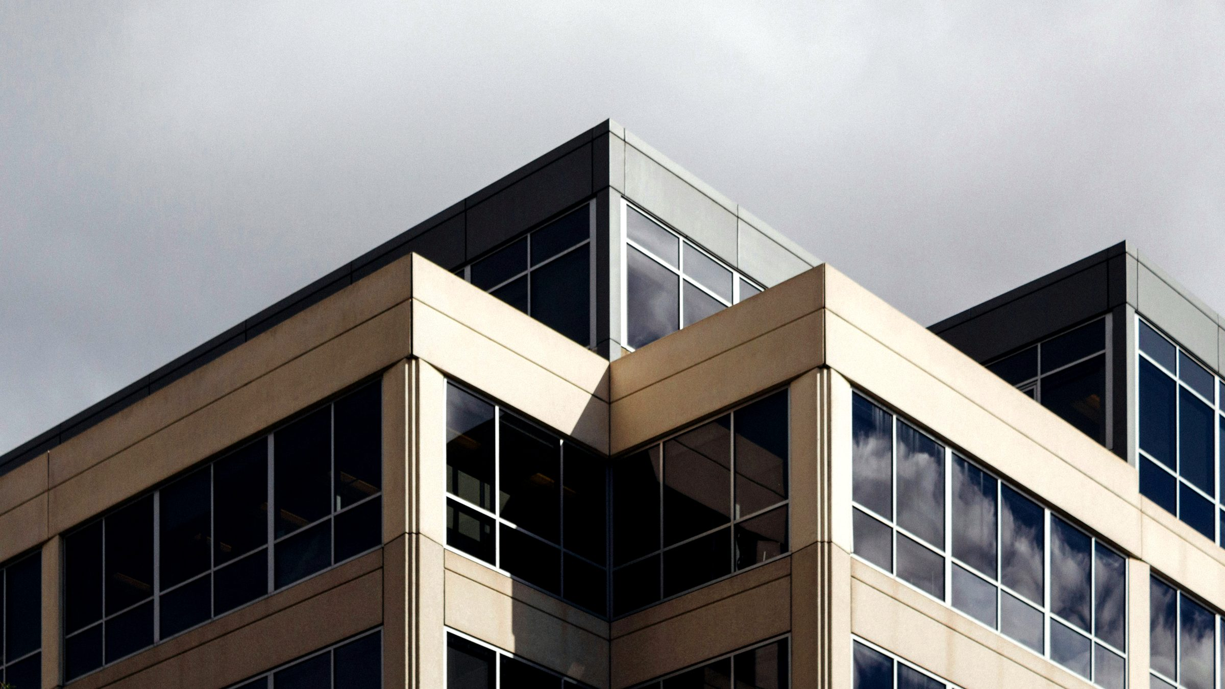 A multi story office building with stone banding and rows of tinted windows
