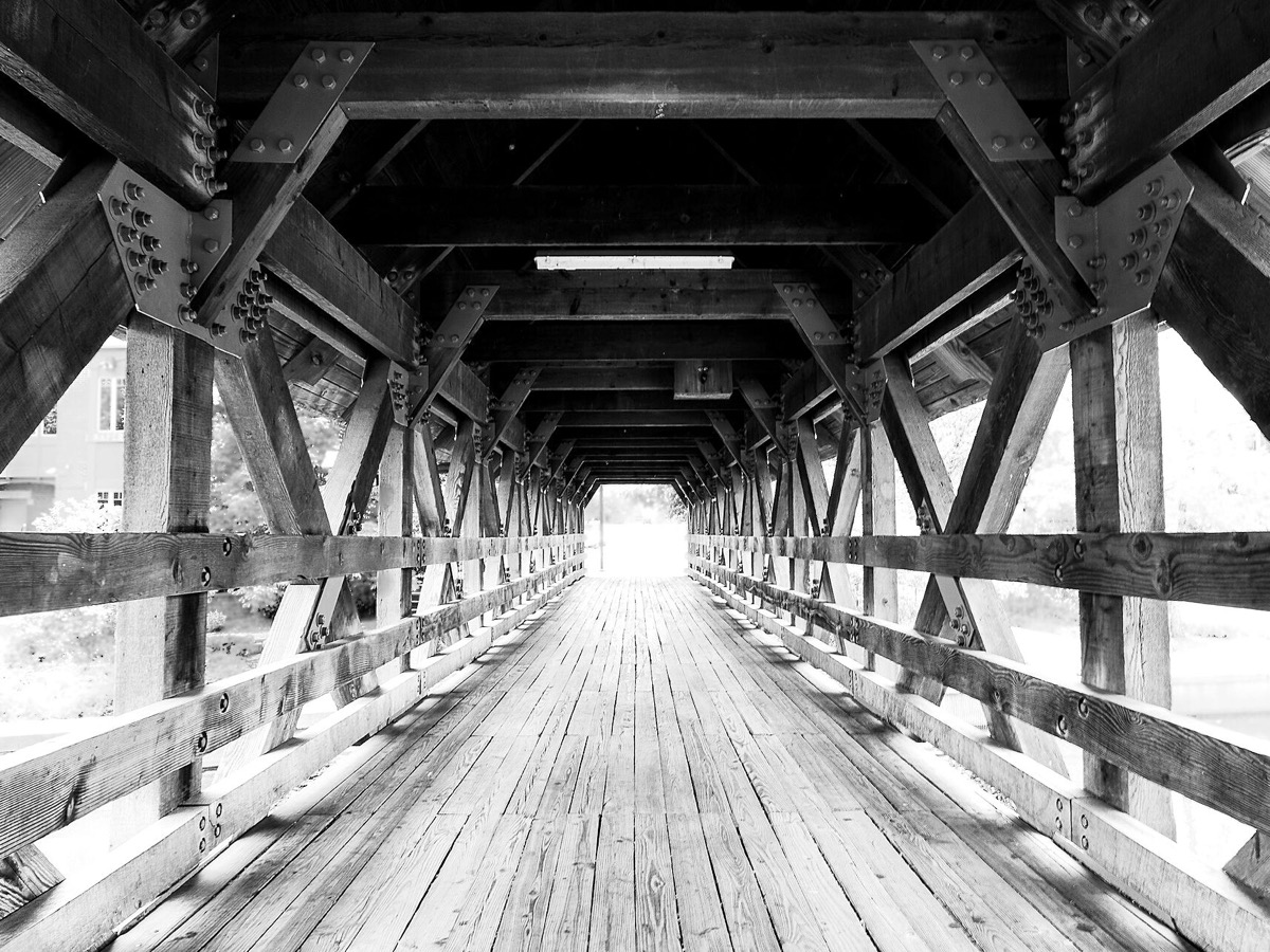 A covered bridge on the Riverwalk in Naperville, Illinois. Photo: Carole J. Buckwalter, CC BY-SA 4.0, via Wikimedia Commons.